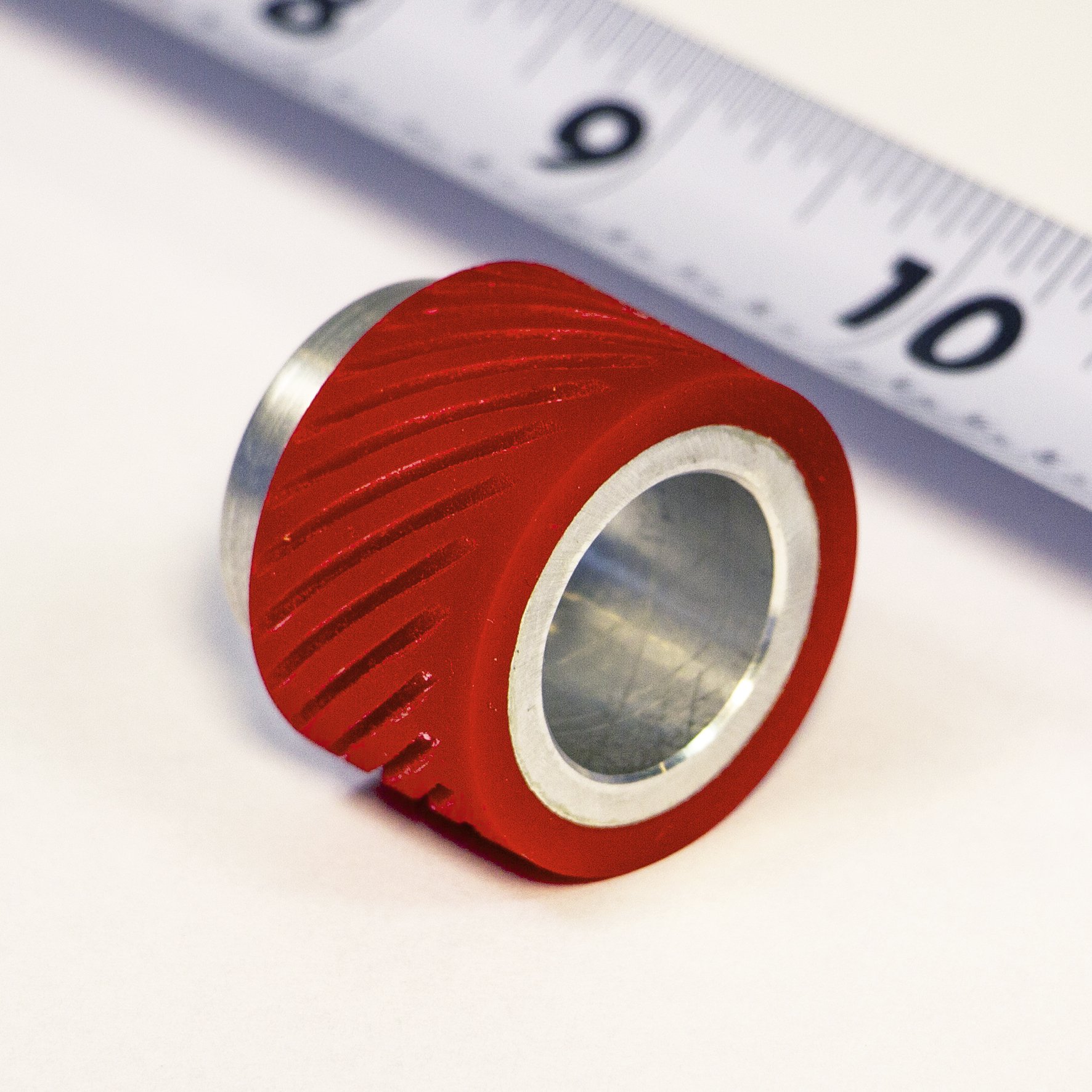 Close up of a red grooved urethane roller